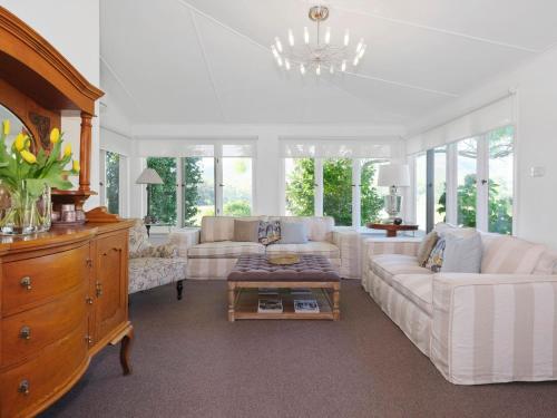 BulgaMeerea Country Estate adjoining Wollombi National Park的客厅配有白色家具和吊灯。