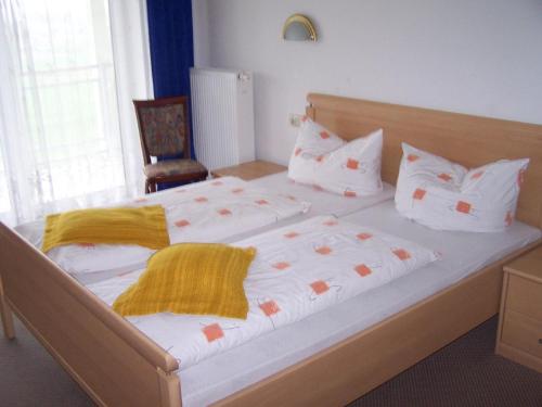 伯根Hotel-Pension Sandl的卧室配有一张带白色床单和枕头的大床。
