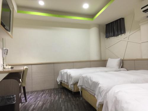 斗六市微旅时尚旅店的一间酒店客房,设有两张床和电视