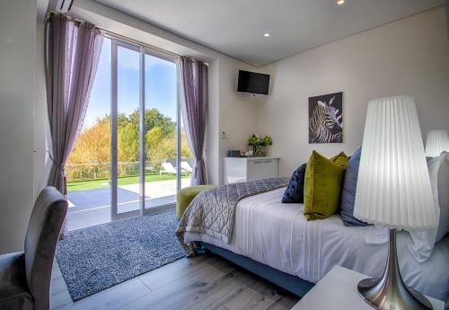 开普敦Badgemore Villa Guesthouse的一间卧室设有一张床和一个大窗户