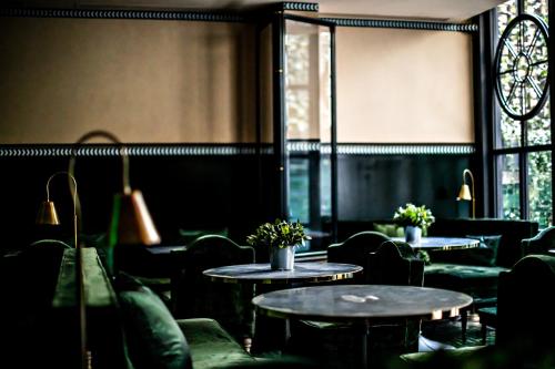 巴黎Monsieur George Hotel & Spa - Champs-Elysées的餐厅设有桌椅和窗户。