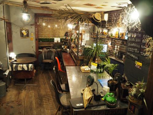 熊本民泊カフェ Gootarian的一间酒吧,里面摆放着椅子和桌子