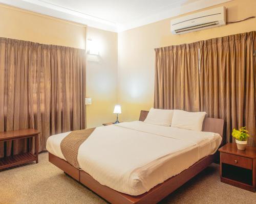 钦奈哈努雷迪华莱士花园住宅的一间卧室配有大床和窗帘