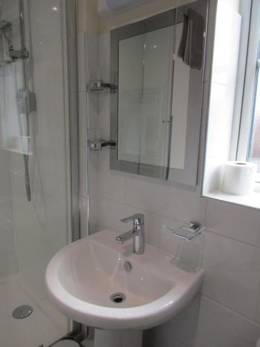 拉格比20 Nightingale Gardens, Coton Park, Rugby CV23 0WT的白色的浴室设有水槽和淋浴。