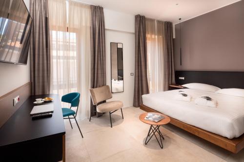 米兰The Corner Duomo Hotel的酒店客房,配有一张床、一张桌子和椅子
