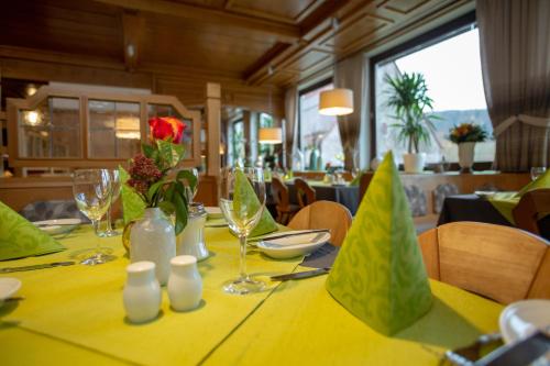 科琴斯顿巴赫苏姆阿特施罗斯兰迪伊尔酒店的餐厅的一张桌子,上面有黄色的桌布