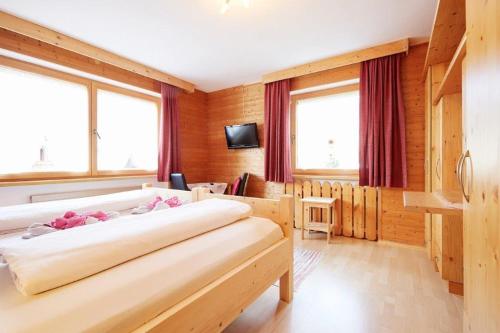 GrafenwegBettys Ferienwohnung的一间卧室设有两张床和两个窗户。