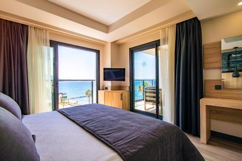 古泽尔坎里MAIA Luxury Beach Hotel & Spa的一间卧室设有一张床,享有海景