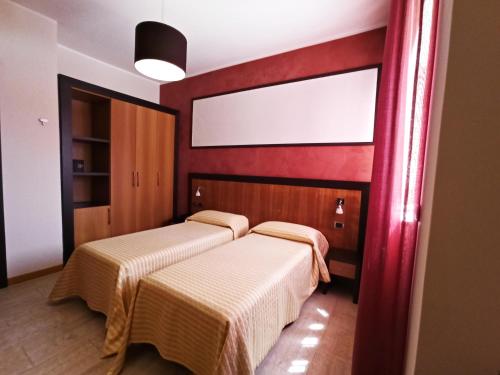 库特罗菲安诺Hotel Naitendì的红色墙壁客房的两张床
