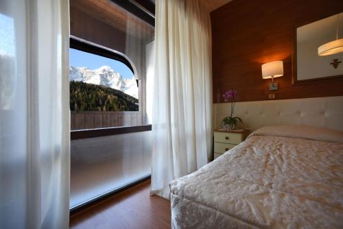 瓦尔迪佐多可乐娜酒店的一间卧室设有一张床和一个山景窗户。