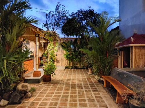 沙努尔Kubu Di-Kayla's的种有棕榈树和长凳的庭院