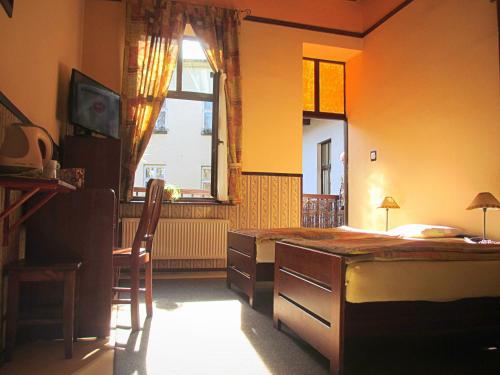 克拉科夫格罗布托特旅馆的一间卧室配有一张床、一张书桌和一个窗户。
