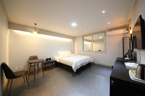 木浦市木浦贵宾酒店的酒店客房带一张床、一张桌子和椅子