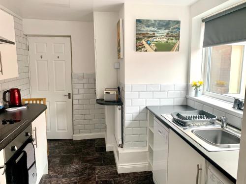 MonkwearmouthMilburn Cottage 2- Luxury Accommodation的白色的厨房设有水槽和窗户
