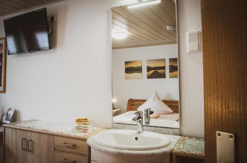 阿尔斯费尔德餐厅/迈因策尔图尔膳食旅馆的一间带水槽和大镜子的浴室