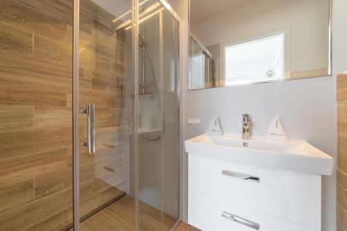 亚斯塔尔尼亚Marina Domki Apartamentowe的一间带水槽和淋浴的浴室