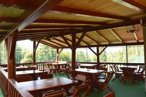 丰达塔Resort EuroPark Fundata的餐厅设有木桌、椅子和窗户。