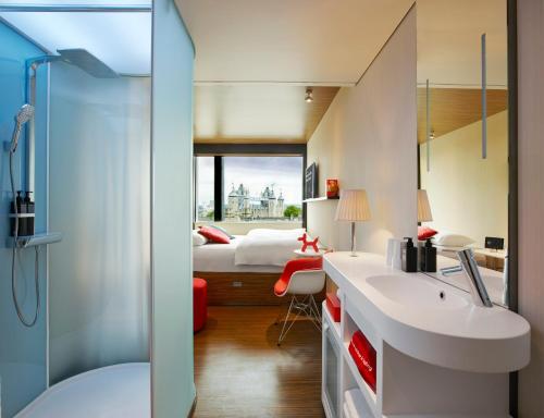 伦敦伦敦塔世民酒店的一间带水槽的浴室和一间带一张床的卧室
