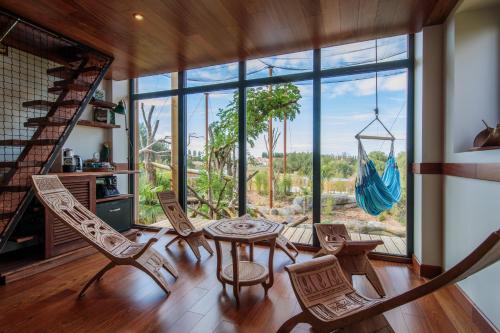 克雷西拉沙佩勒Parrot World - Les Lodges的客房设有桌椅和大窗户。