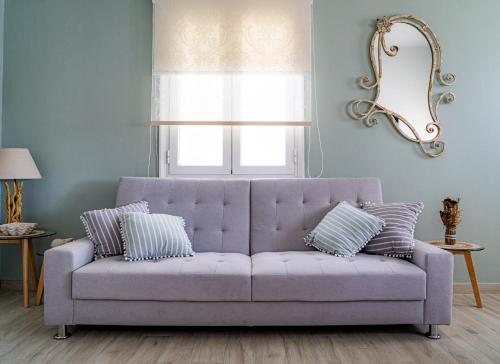瓦里Ostraco Syros的客厅里设有紫色沙发,配有窗户