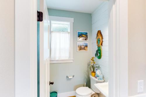 林肯市Mermaids Grotto的一间带白色卫生间的浴室和窗户。