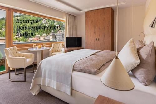 圣莫里茨阿尔特酒店的一间卧室配有一张床、一张桌子和一台电视