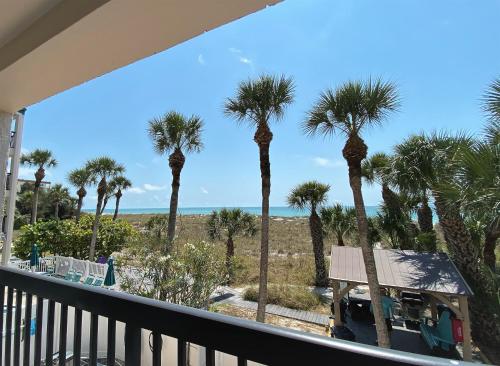 圣徒皮特海滩自由全季公寓式度假酒店的棕榈树阳台享有海滩美景。