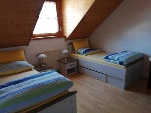 德根多夫Schöne Wohnung in Deggendorf für 1 bis 5 Personen的阁楼间设有两张床和两扇窗户