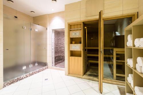 卡萨诺韦Crowne Plaza Milan - Malpensa Airport, an IHG Hotel的浴室设有步入式衣柜和玻璃门