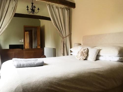 WiggintonOak Barn的卧室配有一张带白色床单和枕头的大床。