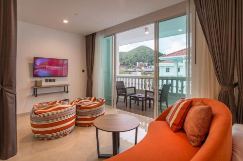 奥南海滩Centara Ao Nang Beach Resort & Spa Krabi - SHA Plus的一间带橙色沙发的客厅和一个阳台