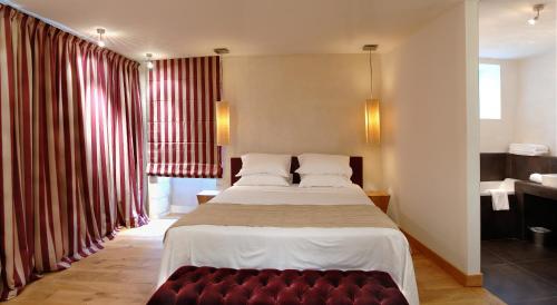 沙布利Au Vieux Moulin的一间卧室配有一张大床和一张红色的沙发