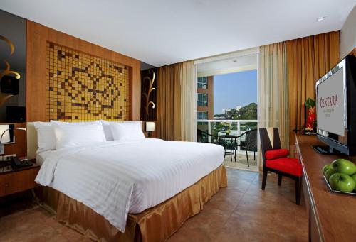 芭堤雅市中心Centara Nova Hotel Pattaya的酒店客房设有一张大床和一台电视。