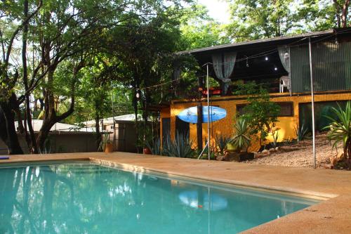 塔马林多Casa Pura Vida Surf Hostel - Tamarindo Costa Rica的房屋前的游泳池