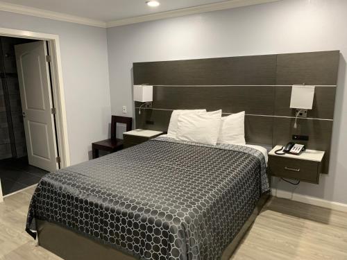 旧金山米拉其套房汽车旅馆的一间卧室配有一张大床和木制床头板