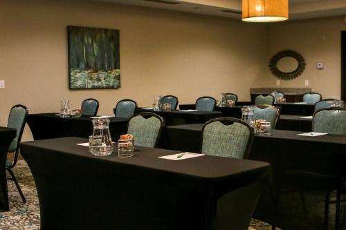 森特尼尔Holiday Inn & Suites Denver Tech Center-Centennial, an IHG Hotel的一间设有桌椅的会议室和一幅画