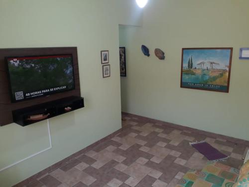 瓜鲁雅Apartamento na enseada 50 metros da praia的客厅设有壁挂式平面电视。
