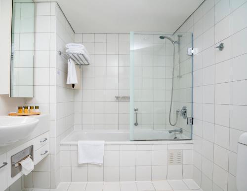 奥克兰The Spencer Hotel的带淋浴和盥洗盆的白色浴室