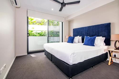 巴迪纳Hedge Apartments by CLLIX的一间卧室配有一张大床和蓝色床头板