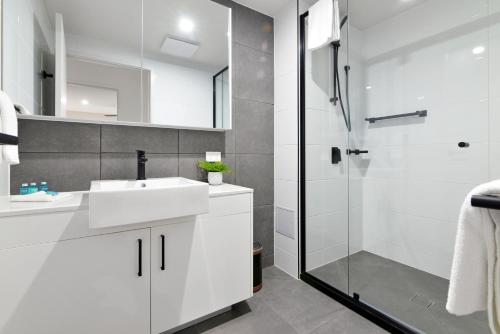 巴迪纳Hedge Apartments by CLLIX的浴室配有白色水槽和淋浴。