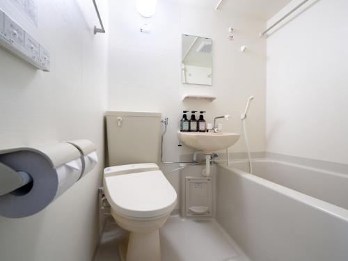 气仙沼市气仙沼市代理商旅馆的白色的浴室设有卫生间和水槽。