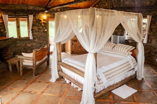 奈瓦沙Honeymoon Hut的一间卧室配有一张带天蓬的床