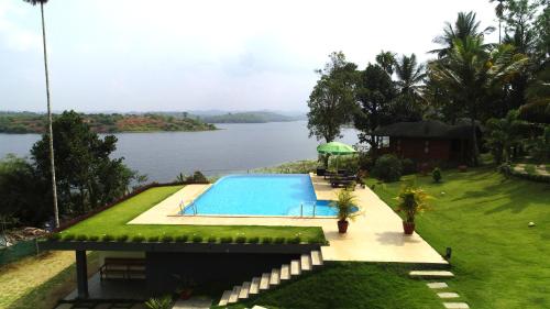 卡尔佩特塔Room in Villa - LakeRose Wayanad Resort的水体旁边的游泳池