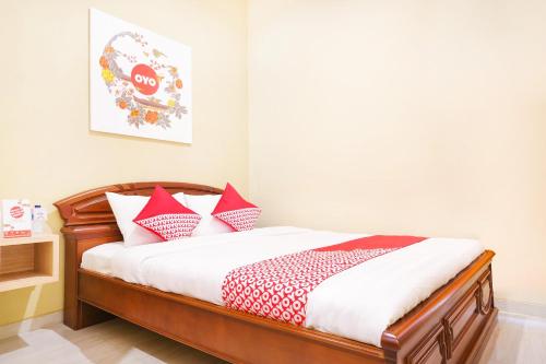 日惹OYO 90033 DeHome Family的一间卧室配有红色和白色枕头的床