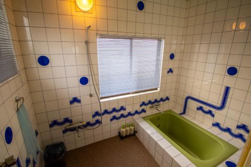 濑户内市库罗氏玛如旅馆的一间带绿色浴缸和窗户的浴室