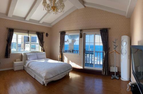 济州市格里姆度假酒店的一间卧室设有一张床,享有海景
