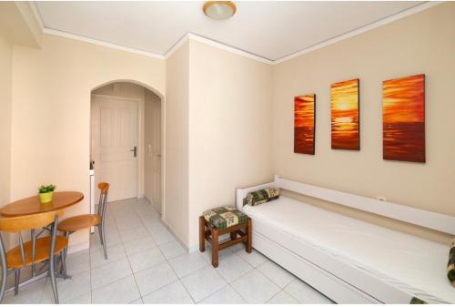阿依亚埃夫菲亚海神公寓式酒店的客厅配有长凳和桌子