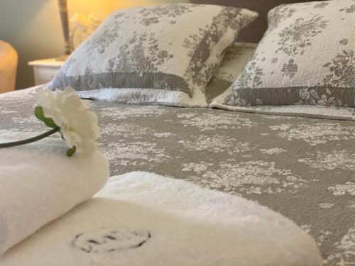 米雷Le Moulin de Rudelle的床上有枕头,上面有白色的花