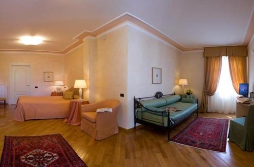 郎世宁蒂内拉Albergo Castiglione Langhe的一间带床和沙发的客厅以及一间带