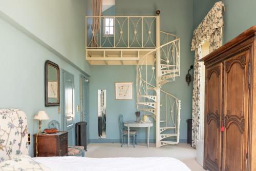 索沃泰尔瓦亭城堡酒店的一间卧室设有蓝色的墙壁和螺旋楼梯。